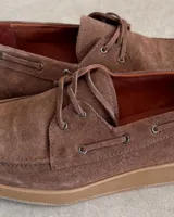 Zapato náutico marrón de cuero vacuno con cordones y suela plana.