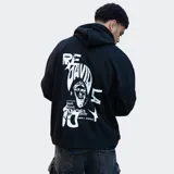 Canguro negro con capucha y cordones ajustables, bolsillo tipo canguro y logo 'Relajo' estampado en el pecho.