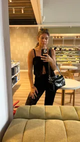 Top de encaje negro con breteles finos y escote con abertura.