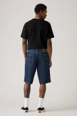 Bermuda de jean azul oscuro, corte holgado y largo hasta la rodilla.