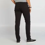 Pantalón de jean negro, corte slim fit, con bolsillos delanteros y traseros.