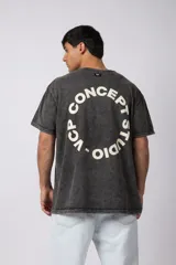 Remera oversize de algodón con efecto lavado gastado, cuello redondo y mangas cortas. Presenta un diseño circular estampado en el pecho con el texto VCP CONCEPT STUDIO.