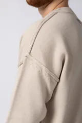 Sweater de punto grueso en color verde oliva, con diseño oversized, cuello redondo y mangas largas con puños acanalados.