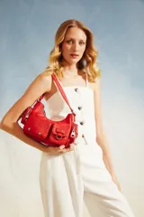 Cartera tipo baguette de color rojo, con múltiples bolsillos frontales, herrajes metálicos plateados y correa ajustable.