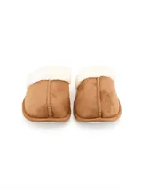 Pantuflas de gamuza color tostado con interior de piel sintética blanca y costuras decorativas frontales.