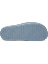 Ojotas Under Armour modelo W Armr Slide Lite de color gris, confeccionadas en EVA moldeada de una sola pieza. Presenta una tira ancha con textura geométrica y el logo de la marca en relieve.
