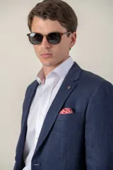 Saco de lino color beige, corte slim fit, con solapa de muesca, cierre de dos botones, bolsillo en el pecho y dos bolsillos delanteros con solapa. Medio forro.