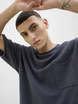 Remera azul de algodón con cuello redondo, manga corta, corte holgado y bolsillo en el pecho.