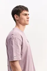 Remera oversize azul marino con efecto lavado, manga corta y cuello redondo. Cuenta con un pequeño estampado gráfico frontal con texto blanco y diseño XL en la espalda.