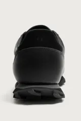 Zapatilla deportiva para hombre fabricada en piel, con diseño de paneles combinados y suela dentada.