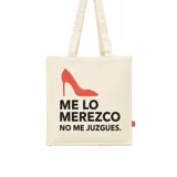 Tote bag de tela color crudo con estampado frontal de un zapato de tacón rojo y la frase 'ME LO MEREZCO NO ME JUZGUES.' en color negro. Cuenta con dos asas largas para llevar al hombro.