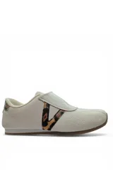 Zapatillas casuales color beige con cierre de velcro, detalle de animal print en el lateral y en el talón, y costuras decorativas en la puntera.