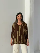 Sweater de punto color chocolate con estampado abstracto en color dorado, cuello en V y diseño holgado de manga larga.