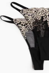 Pack de dos colaless de tiro bajo, confeccionadas en malla negra con apliques de encaje floral en tono beige. Poseen laterales finos y refuerzo interior.