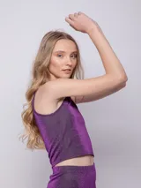 Top asimétrico de tela brillante color azul, sin mangas.