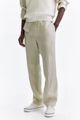 Pantalón de lino liviano para hombre, de corte regular fit y color beige. Presenta cintura elástica con cordón de ajuste oculto, bolsillos laterales discretos y un bolsillo trasero insertado.