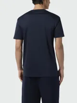 Camiseta de manga corta color azul marino con cuello redondo y un pequeño logo bordado de calavera y tibias cruzadas en blanco en el pecho.