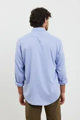 Camisa de vestir para hombre, color azul claro, de manga larga y cuello italiano. Tejido texturado y suave, confeccionada en una mezcla de algodón y poliéster.