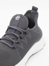 Zapatillas deportivas de tejido de punto color gris oscuro, con cordones a tono y suela blanca gruesa. Presentan un logo blanco en la lengüeta.