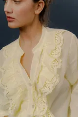 Camisa verde de manga larga, con volados frontales y detalles de puntilla bordada.