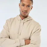 Buzo con capucha color beige, de corte clásico y con bolsillo tipo canguro.