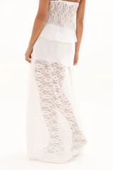 Pollera larga de encaje blanco con diseño de capas y transparencia, de corte fluido y estilo romántico.