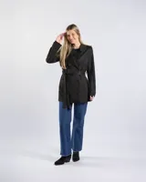 Campera tipo trench negra a la cadera, con solapa cruzada, doble botonadura frontal, hombreras y bolsillos delanteros con solapa.