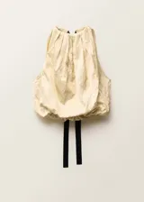 Blusa color crema con cuello halter y lazo de ajuste en la espalda.