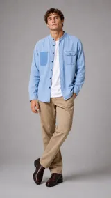 Camisa de jean de manga larga con cuello mao y cierre frontal con botones. Presenta un bolsillo en el pecho y un diseño de lavado claro.