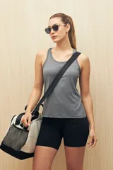 Musculosa deportiva de color gris, con diseño de espalda nadadora (racerback) y corte holgado. Confeccionada en tejido técnico ligero y transpirable, ideal para actividades físicas.