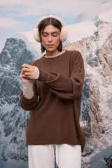 Buzo oversize de tejido de punto con textura acanalada, color blanco, de cuello redondo, manga larga y tajos laterales en el ruedo.