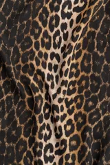 Vestido corto evasé con estampado de leopardo, escote redondo y abertura de cerradura con botón en la nuca. Mangas tres cuartos de corte raglán, pinzas en el busto y bajo recto.