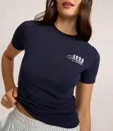 Remera de algodón azul marino, de corte ajustado, con cuello redondo y mangas cortas. Estampa frontal con la leyenda "1996 Barcelona".