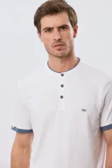 Remera blanca de manga corta con cuello mao y cierre frontal parcial con tres botones. Presenta detalles en color azul en el cuello y en los bordes de las mangas, además de un pequeño logo bordado en el pecho.