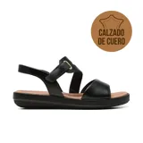 Sandalia plana de cuero color negro, con diseño de tiras cruzadas, cierre ajustable con velcro en el empeine y plantilla acolchada en tono tostado.