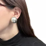 Aros de clip con diseño esférico de acabado metálico plateado y superficie lisa con efecto espejo.