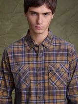 Camisa de pana color azul marino, con mangas largas, cuello clásico y dos bolsillos frontales con solapa y botón.