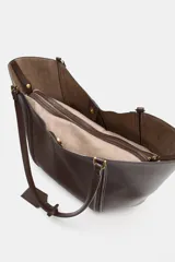 Bolso de hombro tipo maxi shopper, color beige claro, con pespuntes verticales en el cuerpo y doble asa. Incluye un bolso interior con cierre de cremallera metálica y cierre principal imantado.