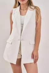 Chaleco sastrero blanco sin mangas, con solapas y cierre frontal con un botón. Posee bolsillos simulados.