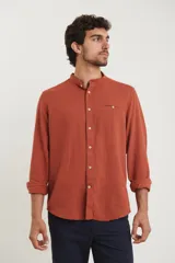 Camisa de cuello mao y manga larga, confeccionada en una mezcla de lino y algodón. Presenta un diseño de corte recto con botones en tono natural y un bolsillo pequeño en el pecho.