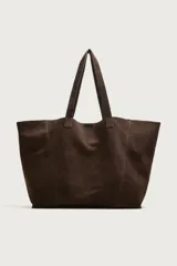 Bolso tipo shopper de gran tamaño confeccionado en piel con acabado de serraje. Presenta un diseño minimalista con costuras visibles, compartimento principal amplio y dos asas de hombro integradas.