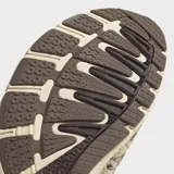 Championes Adidas Adistar Control 5 de estilo running retro, con exterior de malla transpirable en tono beige y detalles con estampado animal print tipo dálmata o vaca en tonos marrones y blancos. Cuenta con las clásicas tres tiras laterales en marrón oscuro, cordones verdes y suela amortiguada.