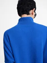 Sweater de cuello alto en punto acanalado, color verde menta, con mangas ajustadas y cuerpo amplio y suelto.