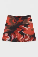 Minifalda estampada con diseño abstracto en tonos rojos y negros, de corte ajustado y cruzado con lazo lateral.