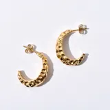 Aros tipo argolla dorados con textura irregular.