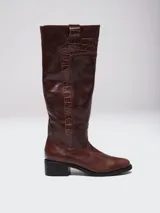 Botas de caña alta color marrón, confeccionadas en cuero con textura lisa y paneles laterales con efecto croco. Cuentan con cierre lateral completo y taco cuadrado bajo.