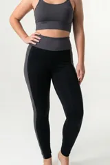 Calza deportiva de tiro alto con cintura elástica reforzada. Presenta un diseño bicolor que combina paneles laterales y faja con estampado animal print en tonos coral y turquesa sobre una base negra.