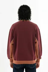 Buzo bordó de corte oversize con cuello redondo, puños y cintura acanalados en color marrón. Presenta paneles laterales con vivo blanco y logo Vernal bordado en el pecho.