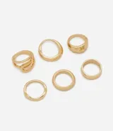 Kit de seis anillos dorados de metal con diseños variados, que incluyen modelos geométricos, bandas lisas y acabados texturizados.