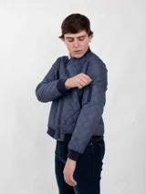 Campera bomber aviador azul con cuello alto, cierre frontal y bolsillos laterales. Diseño acolchado con patrón de rombos.